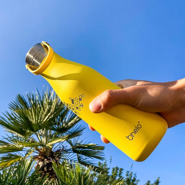 Ohelo yellow bee bottle outside with palm trees